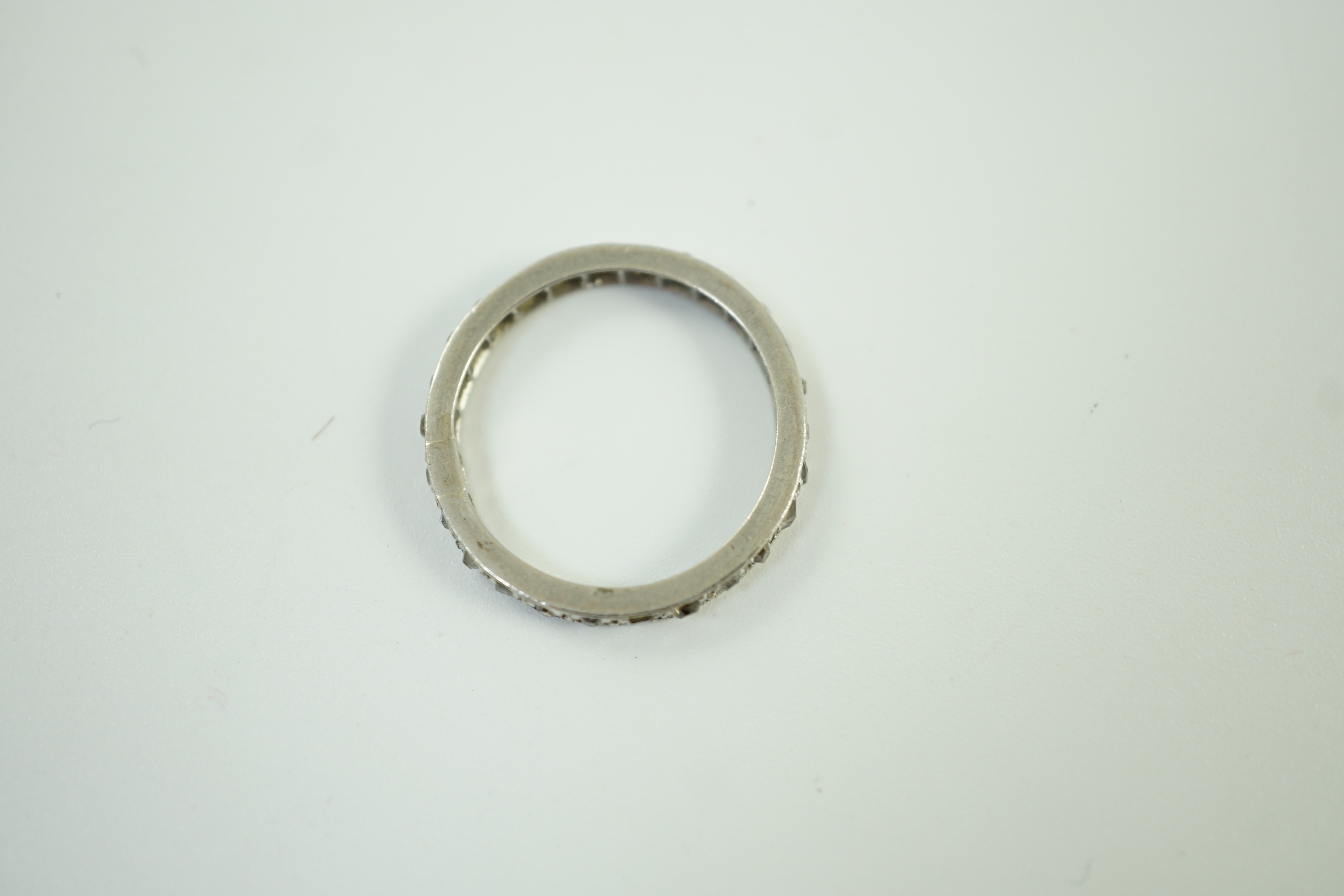 A white metal and diamond chip set full eternity ring, size L, gross weight 2.7 grams.